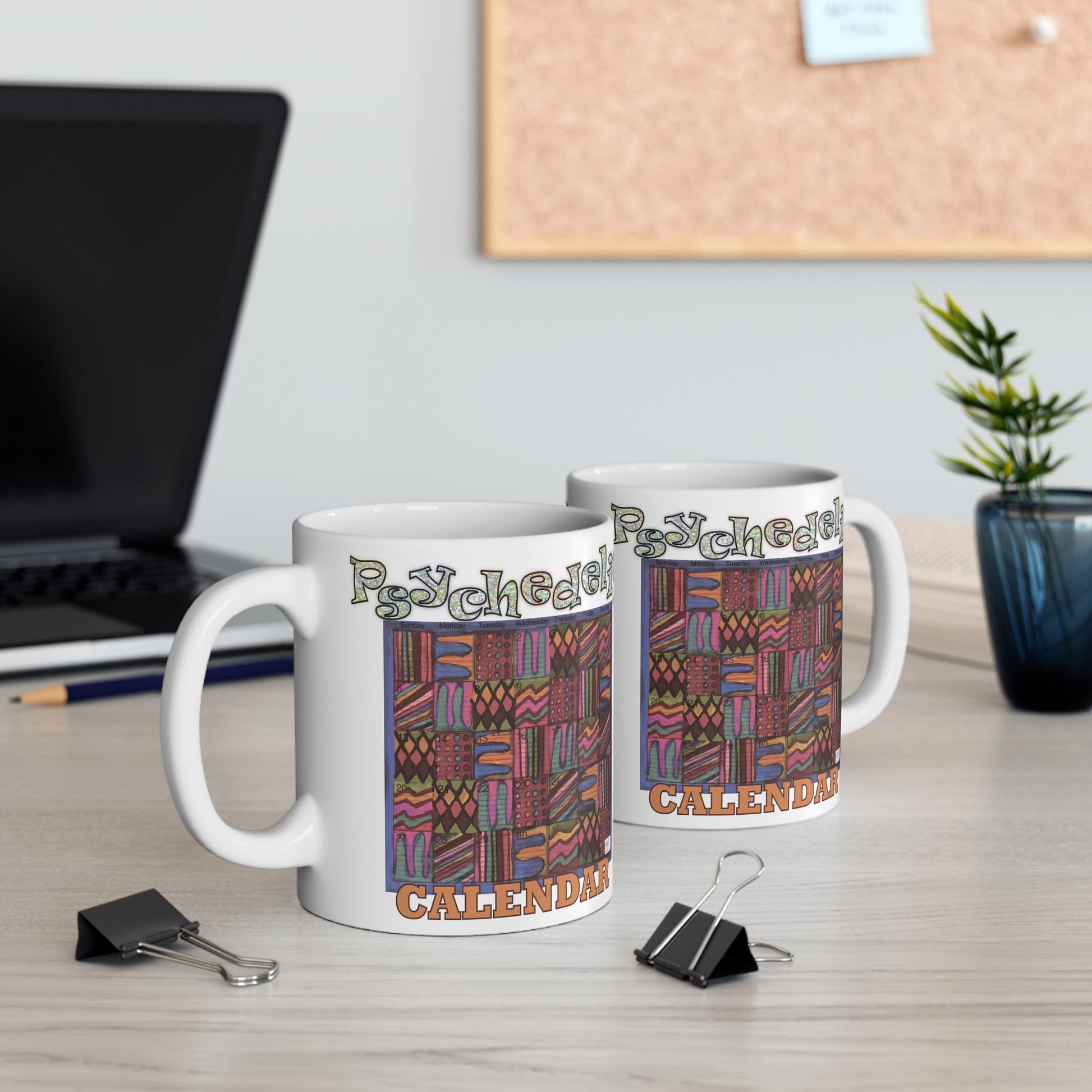 Mug 11oz: Psychedelic Calendar(tm)-Muted- MiE Designs Shop. Subdued mazes switch day2day, Glittery top letters, block style below. Mugs on desk.